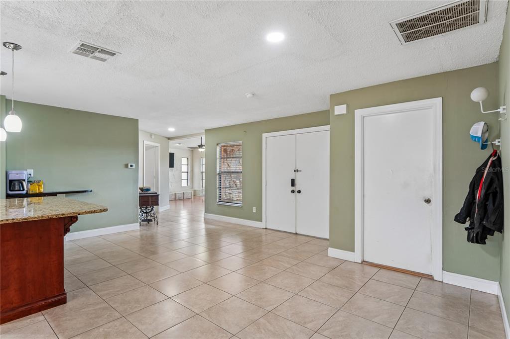 3112 Polk Avenue Spring Hill, FL 34609 - Photo 6 of 50 a view of a livingroom with furniture cabinet flat screen tv and staircase
