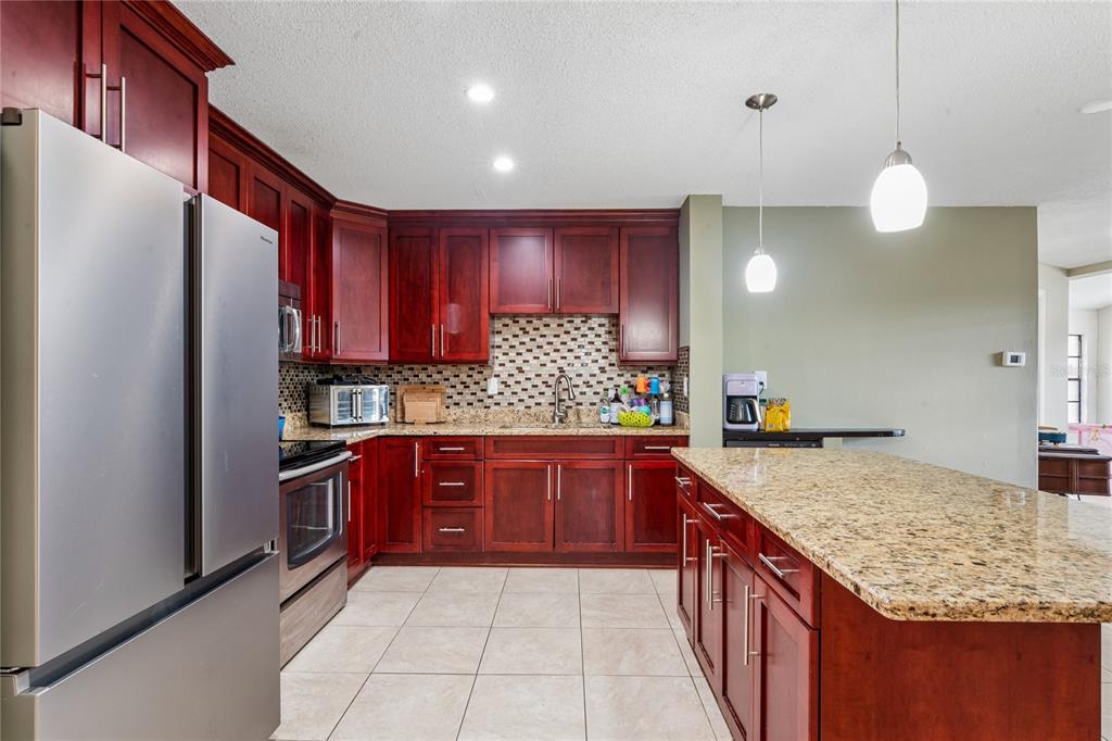 3112 Polk Avenue Spring Hill, FL 34609 - Photo 7 of 50 a kitchen with stainless steel appliances granite countertop a sink refrigerator and microwave