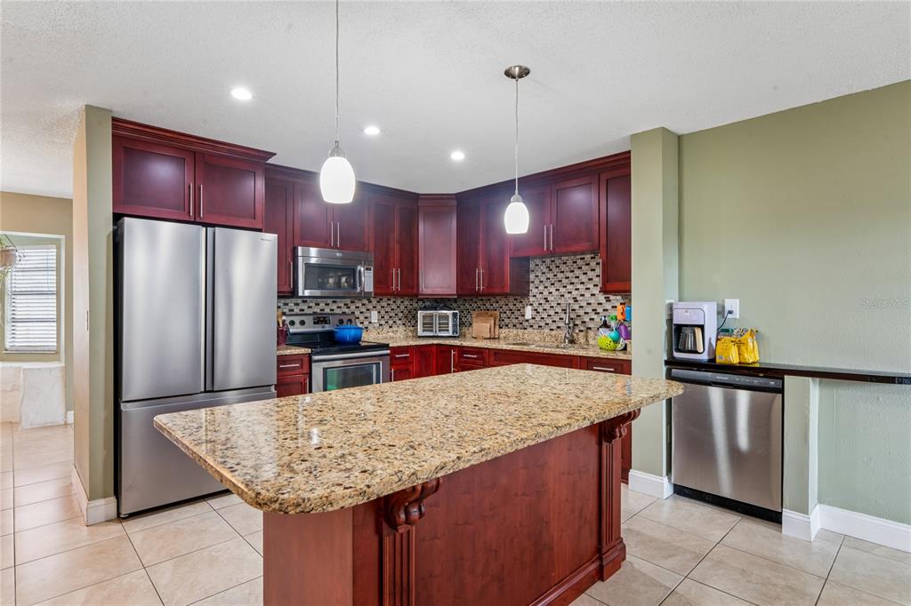 3112 Polk Avenue Spring Hill, FL 34609 - Photo 8 of 50 a kitchen with stainless steel appliances granite countertop wooden counter tops and granite counter tops