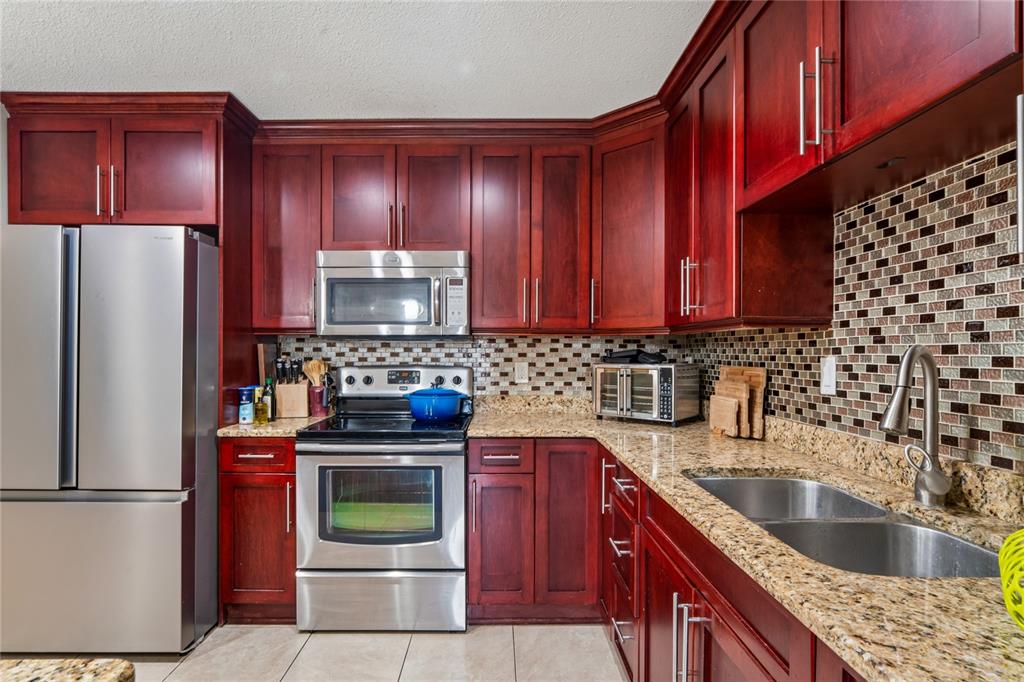 3112 Polk Avenue Spring Hill, FL 34609 - Photo 10 of 50 a kitchen with a refrigerator sink and cabinets