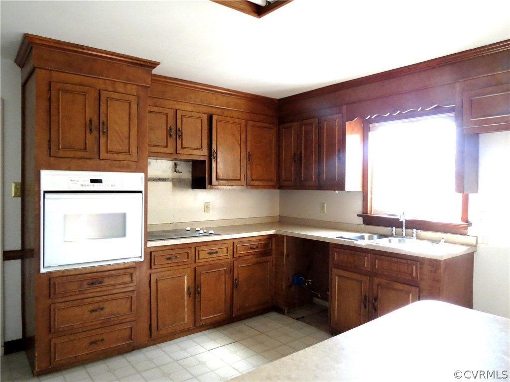 10810 Surry Road Chester, VA 23831 - Photo 11 of 24 a kitchen with a sink a stove and cabinets