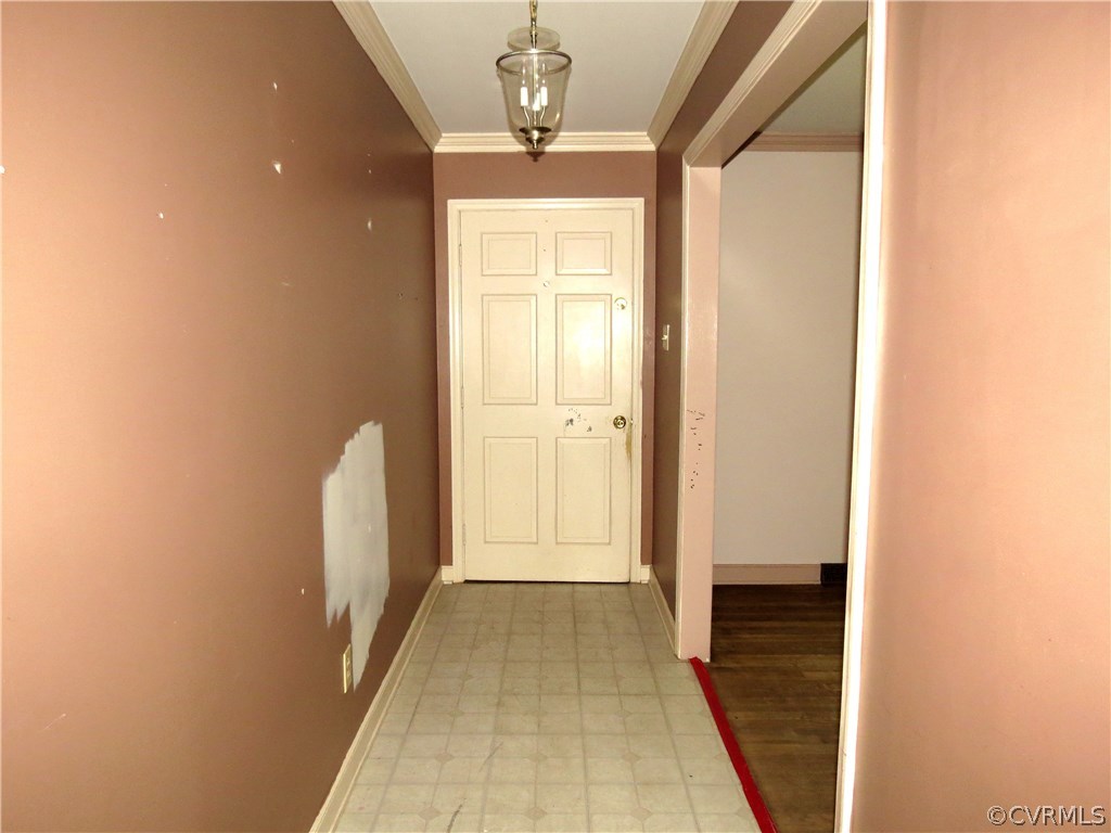 10810 Surry Road Chester, VA 23831 - Photo 4 of 24 a view of a hallway with wooden floor and a chandelier