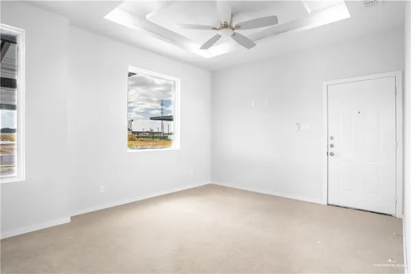 an empty room with windows and fan