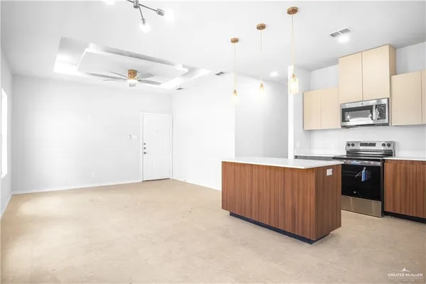 a kitchen with granite countertop a refrigerator a sink and a stove