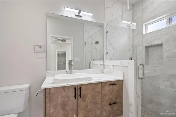 a bathroom with a sink a toilet and shower