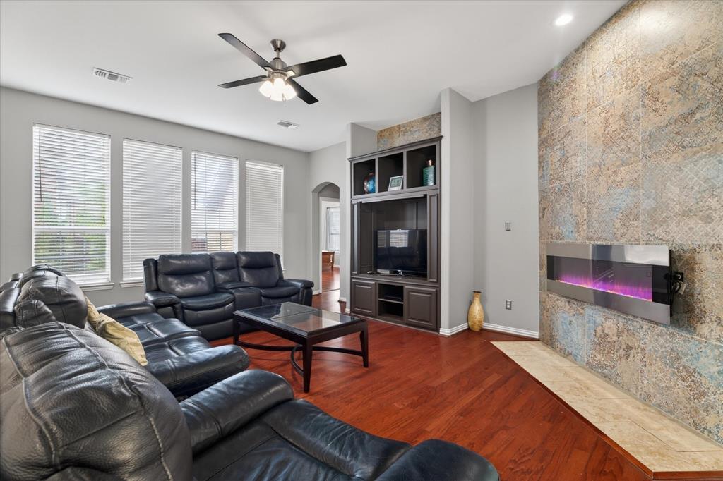 8708 Rugby Road Irving, TX 75063 - Photo 15 of 39 This inviting living space features rich hardwood flooring, a contemporary wall-mounted fireplace with a tiled surround, and recessed lighting