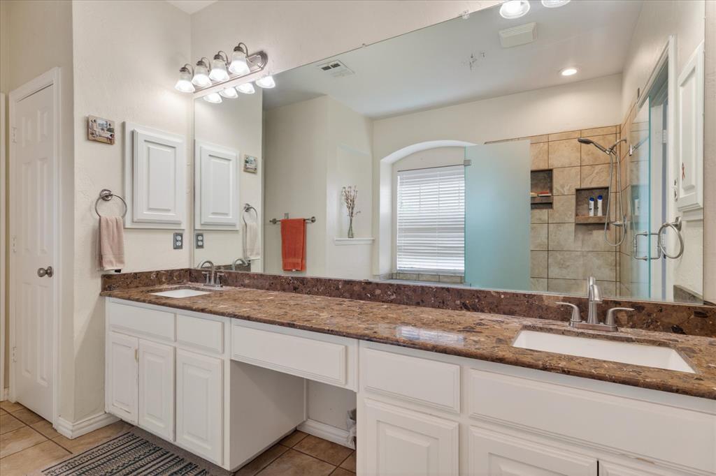 8708 Rugby Road Irving, TX 75063 - Photo 20 of 39 Bathroom featuring a dual vanity with a granite countertop, white cabinetry, and a large mirror