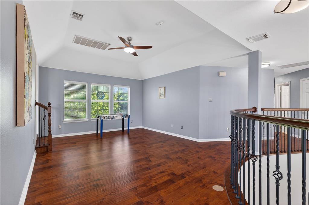 8708 Rugby Road Irving, TX 75063 - Photo 21 of 39 Spacious upper-level area featuring hardwood flooring, vaulted ceilings, and a ceiling fan