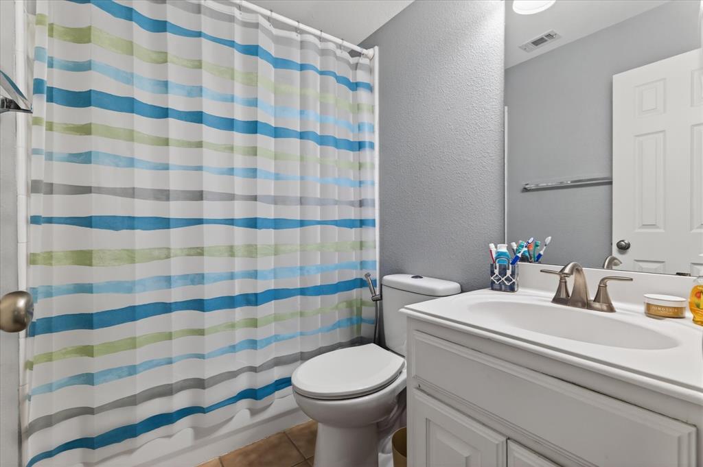 8708 Rugby Road Irving, TX 75063 - Photo 25 of 39 Bathroom features a white vanity with a single basin sink and a toilet