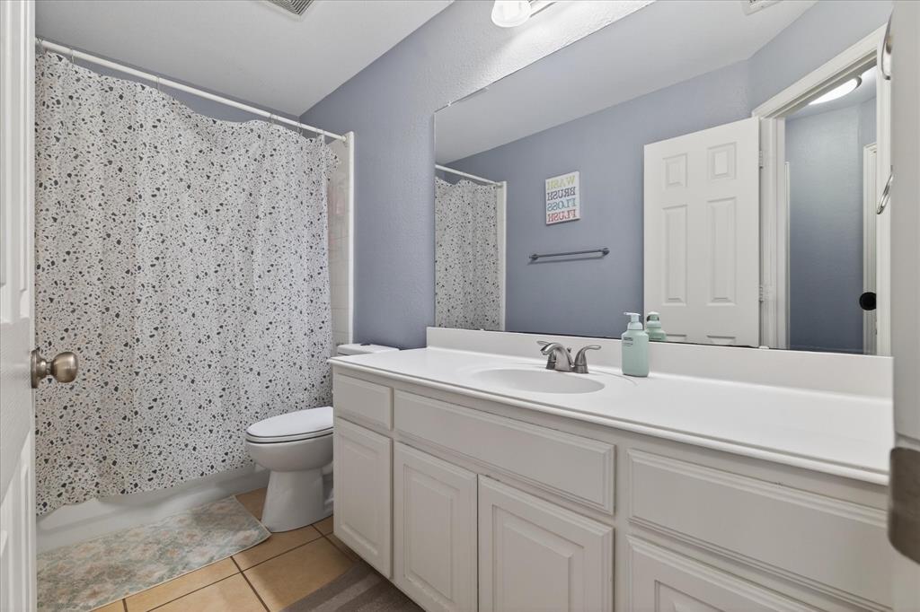 8708 Rugby Road Irving, TX 75063 - Photo 28 of 39 The bathroom features a vanity with white cabinetry, a single sink, and a large mirror