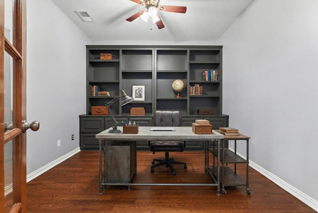 8708 Rugby Road Irving, TX 75063 - Photo 9 of 39 Dedicated space featuring hardwood floors, a ceiling fan, and built-in shelving with lower cabinetry