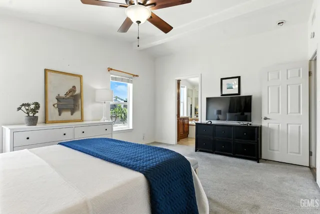 a large bedroom with a bed and a flat screen tv