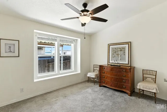 a room with a baby bed a dresser and a window