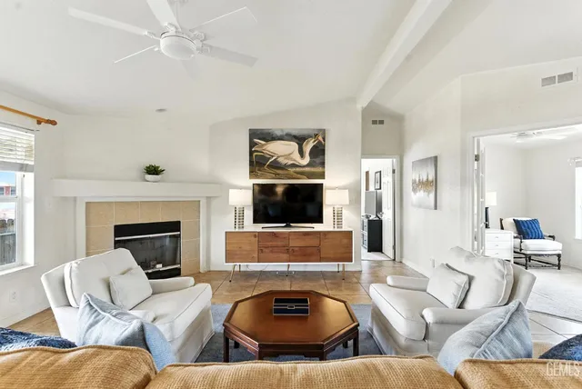 a living room with furniture a fireplace and a flat screen tv
