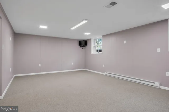 a bedroom with a bed a chair and potted plant on the table