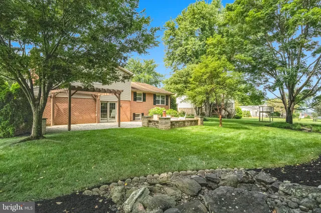 a view of a house with backyard and a tree