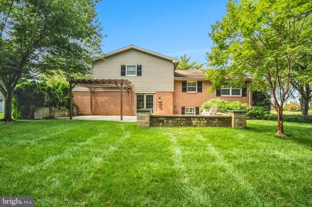 a backyard of a house with fountain table and chairs