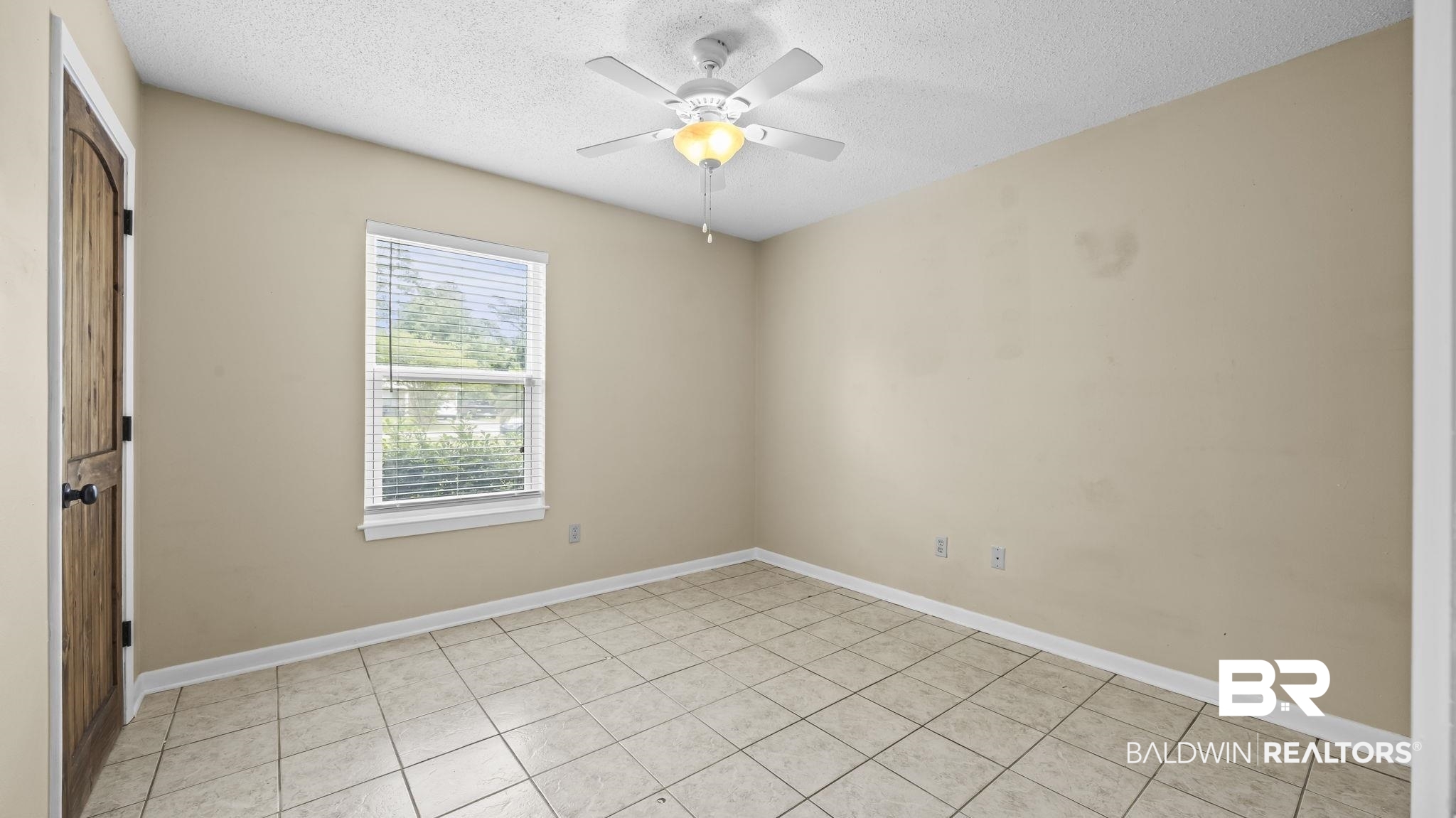 15096 Highland Circle Foley, AL 36535 - Photo 23 of 52 Tile flooring, a single window with blinds, a ceiling fan with integrated lighting, and a wood-finish door