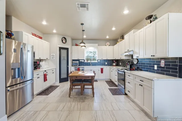 a kitchen with a stove cabinets and white appliances