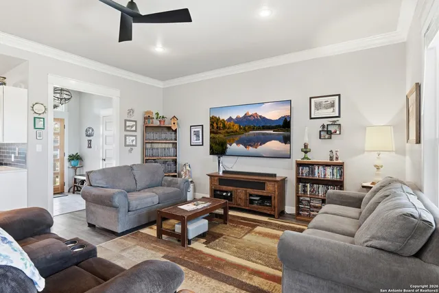 a living room with furniture a flat screen tv and a fireplace