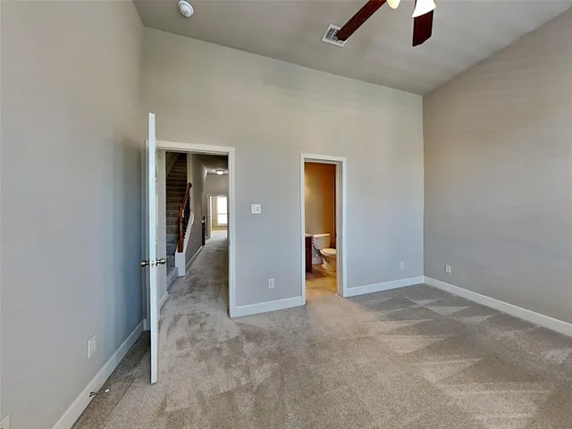 an empty room with closet and a chandelier fan
