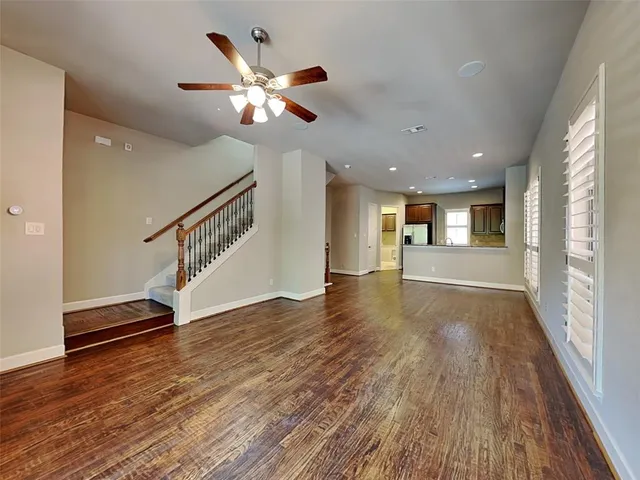 a view of a room with wooden floor staircase and a kitchen