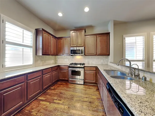 a kitchen with granite countertop a stove sink and cabinets