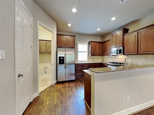 a kitchen with a refrigerator a sink and wooden cabinets