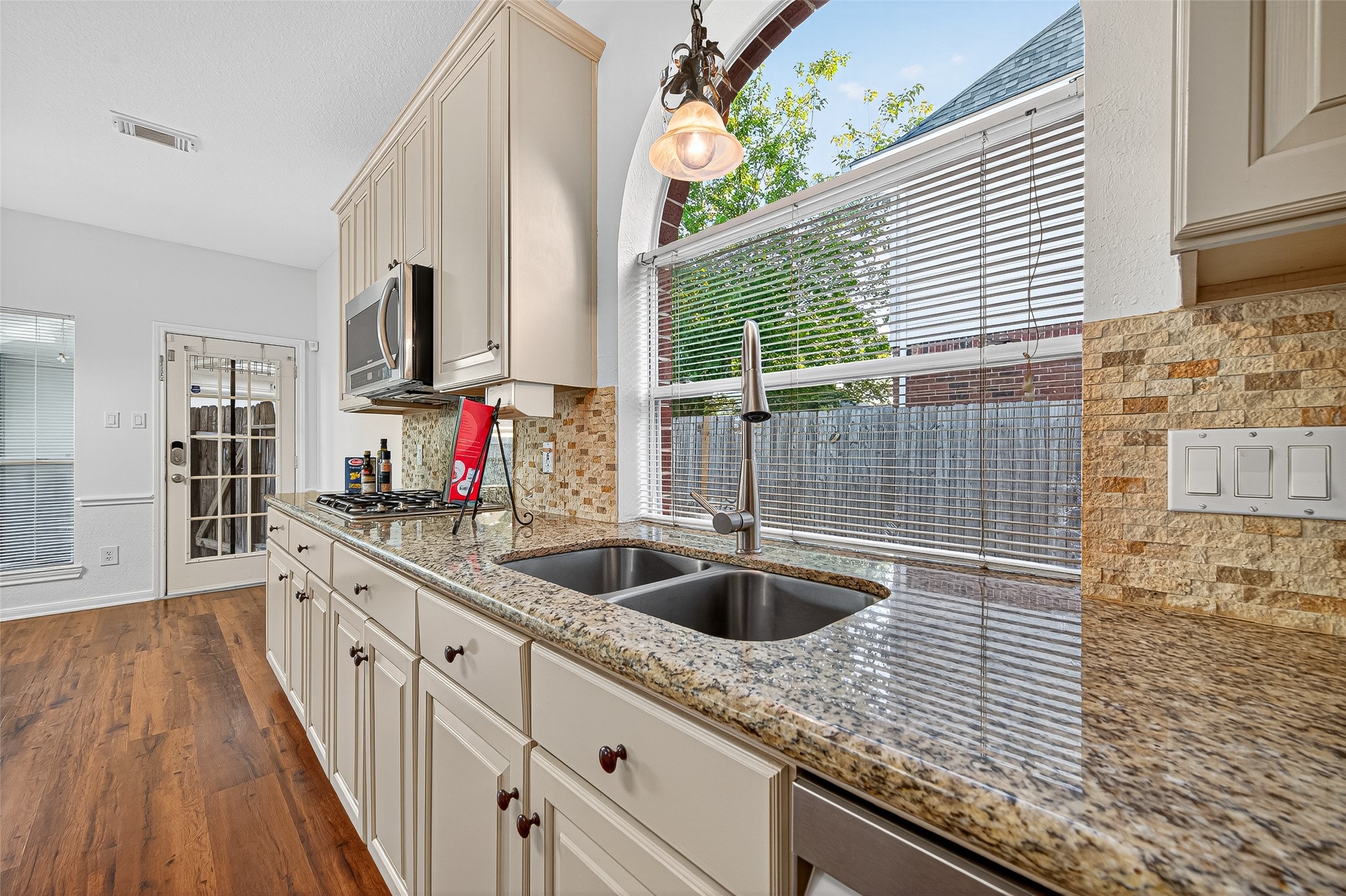 13011 Mossy Ridge Cove Houston, TX 77041 - Photo 18 of 50 a kitchen with granite countertop a sink and a wooden floor