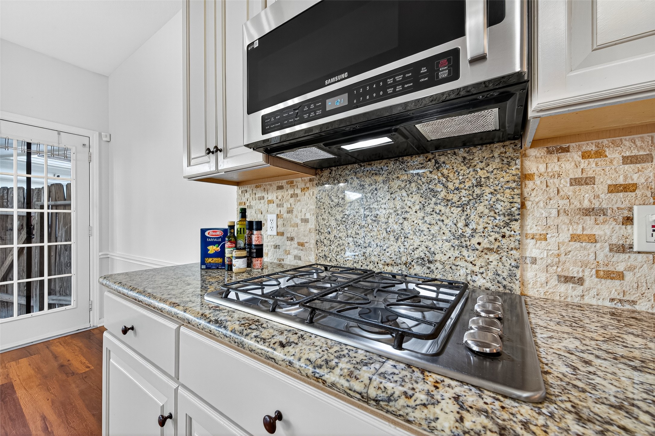13011 Mossy Ridge Cove Houston, TX 77041 - Photo 20 of 50 a kitchen with a stove a microwave and cabinets