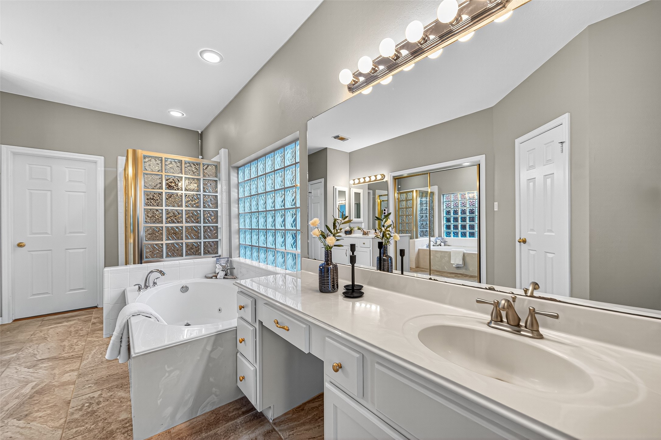13011 Mossy Ridge Cove Houston, TX 77041 - Photo 27 of 50 a bathroom with a tub a double vanity sink a large mirror and a bathtub