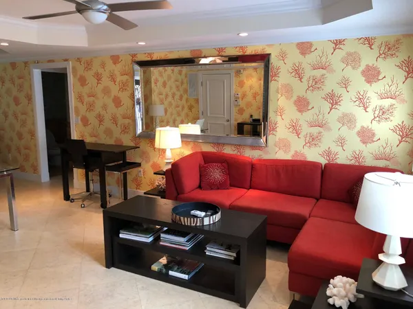 a living room with furniture a large window and a chandelier