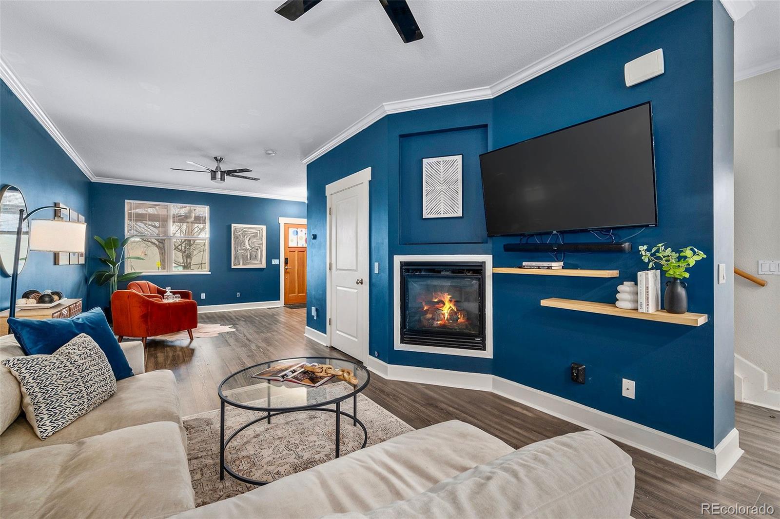 84 Inca Street Denver, CO 80223 - Photo 11 of 32 a living room with furniture a flat screen tv and a fireplace
