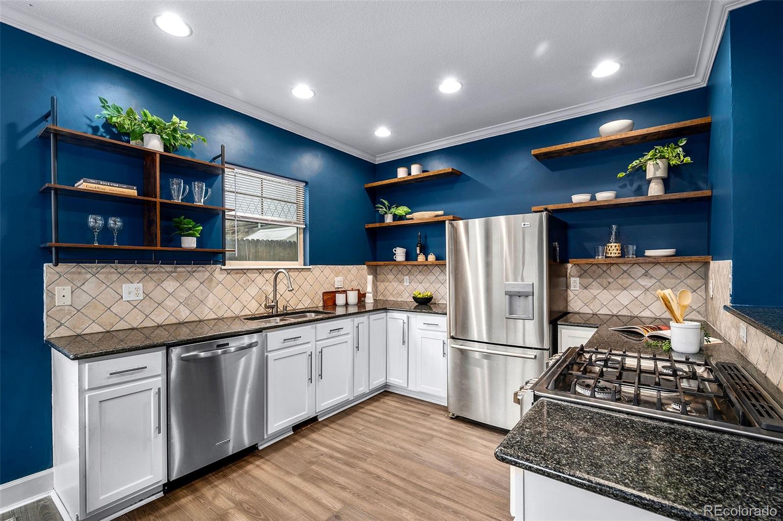 84 Inca Street Denver, CO 80223 - Photo 13 of 32 a kitchen with stainless steel appliances granite countertop a stove a refrigerator and a microwave
