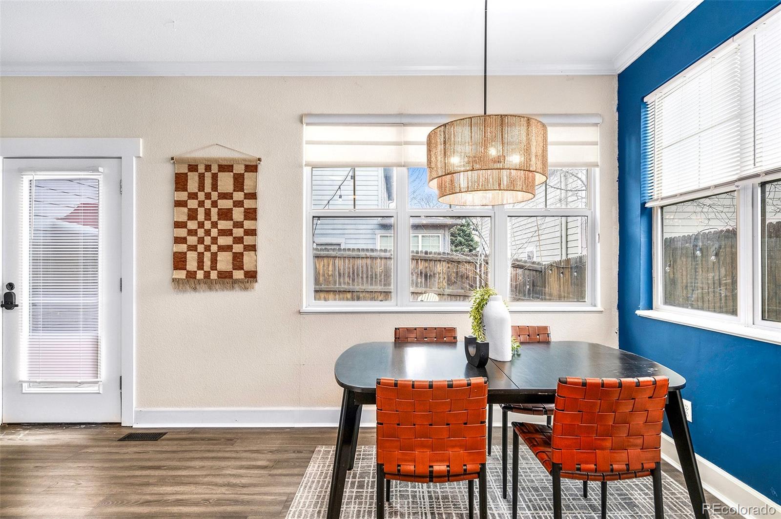84 Inca Street Denver, CO 80223 - Photo 15 of 32 a view of a dining room with furniture a chandelier and wooden floor