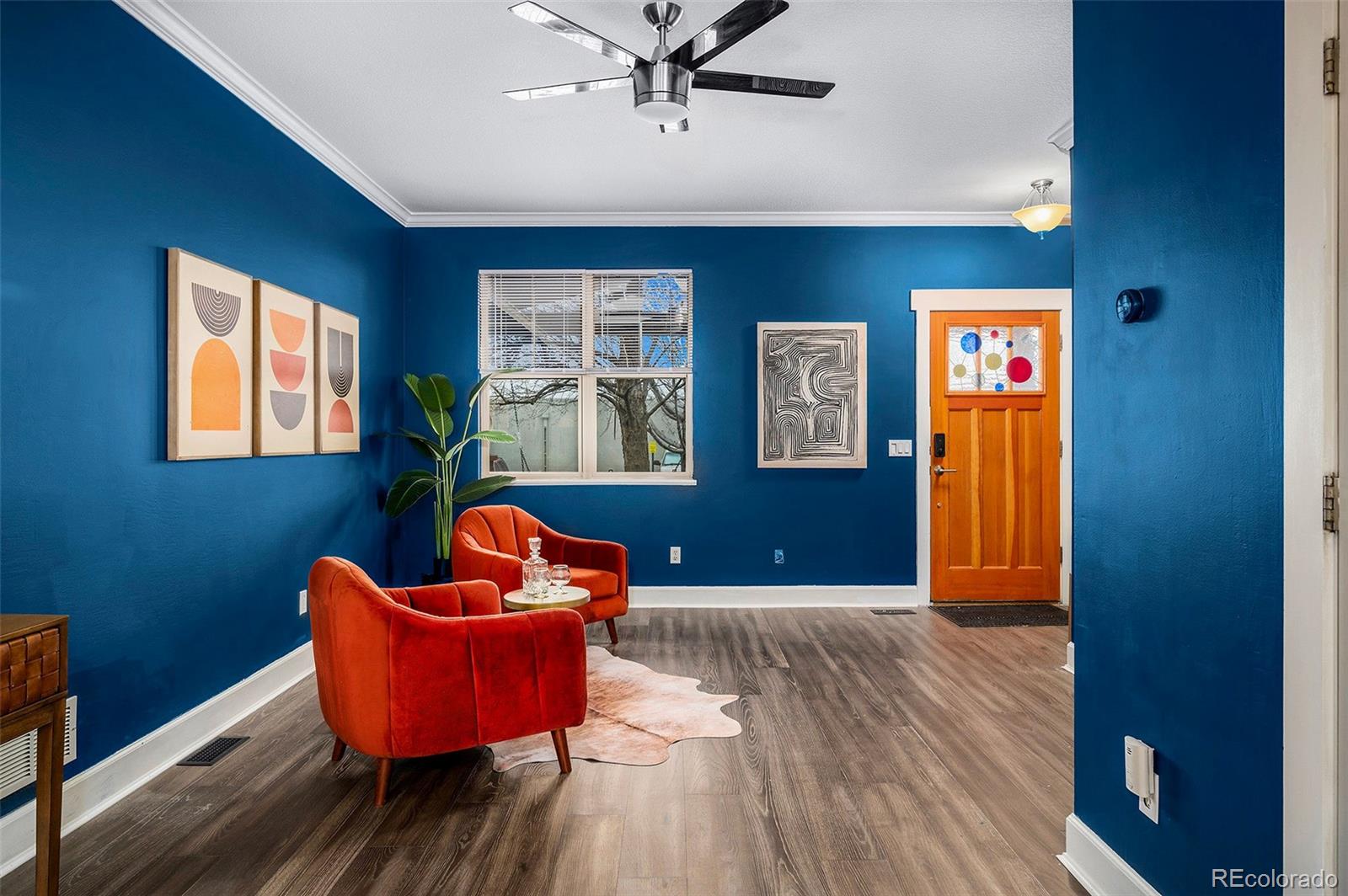 84 Inca Street Denver, CO 80223 - Photo 8 of 32 a living room with blue walls and a wooden floor