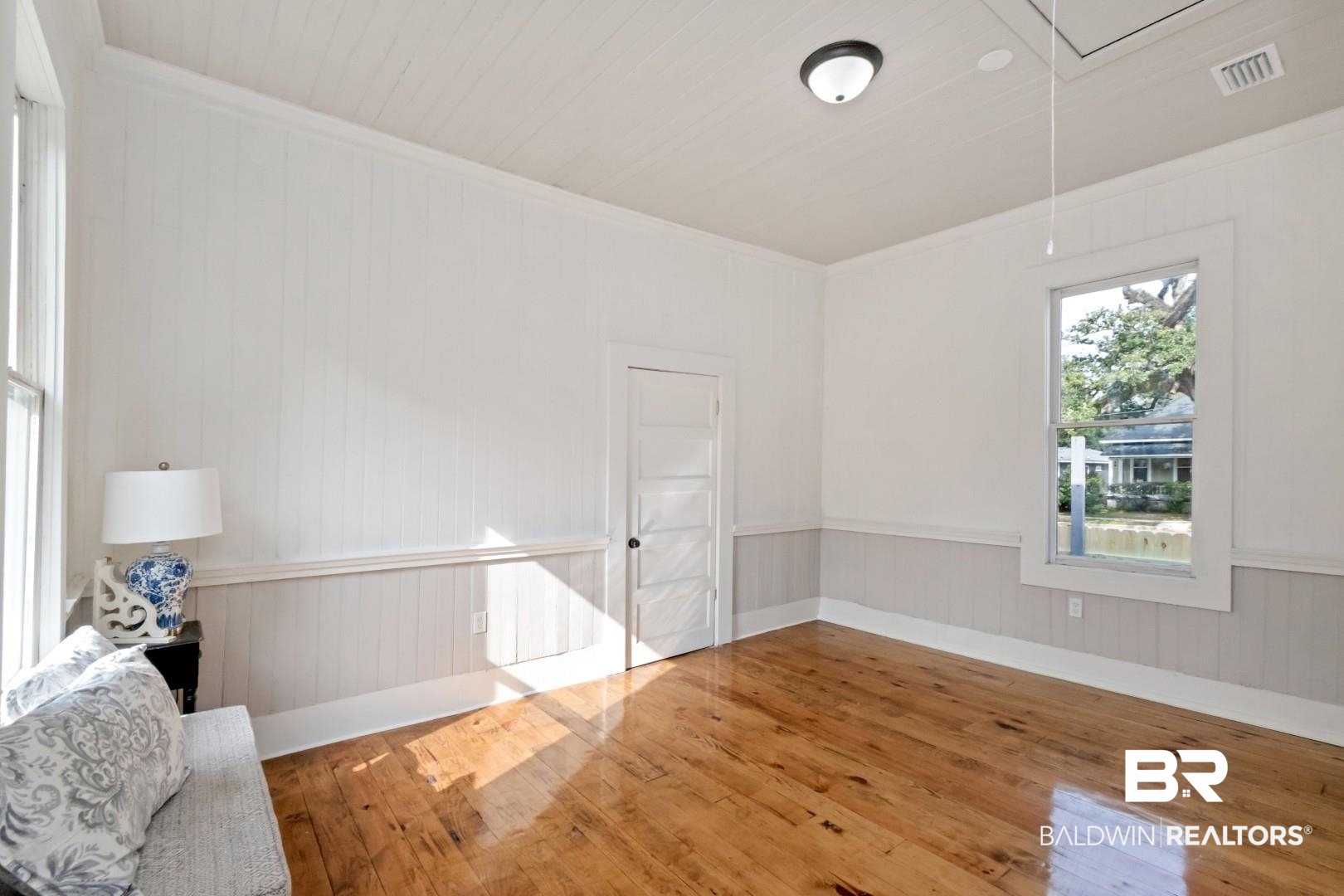 352 Marine Street Mobile, AL 36604 - Photo 11 of 20 Empty room with hardwood / wood-style floors, attic access, crown molding, wooden walls, and a wainscoted wall