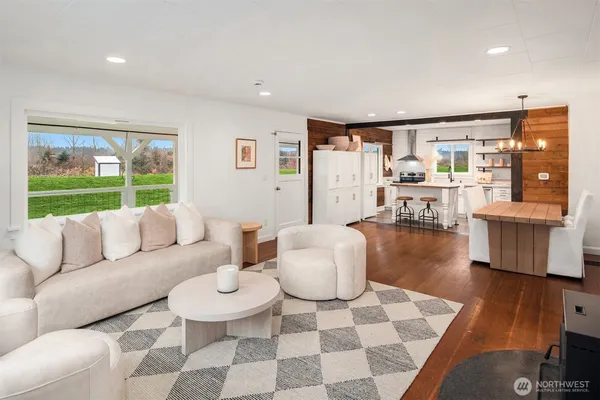 a kitchen with stainless steel appliances granite countertop a sink a stove a refrigerator cabinets and chairs