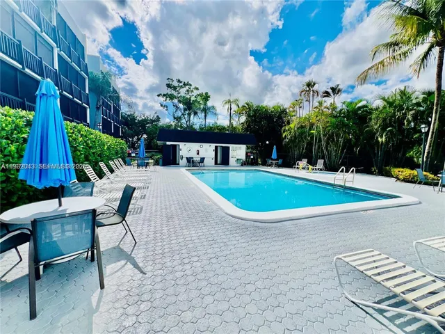a view of a swimming pool with a lounge chair and potted plants