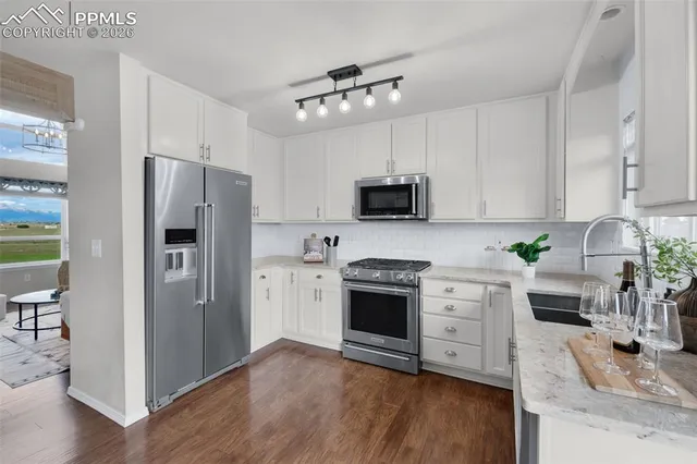 a kitchen with granite countertop a refrigerator stove and sink
