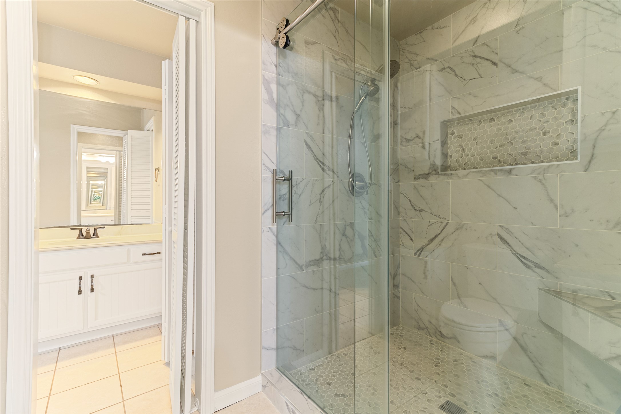 57 South Bachelor Button Street Lake Jackson, TX 77566 - Photo 16 of 29 Freshly remodeled in 2025, the primary walk-in shower showcases tile work & a sleek sliding frameless glass door for a modern, spa-like feel.