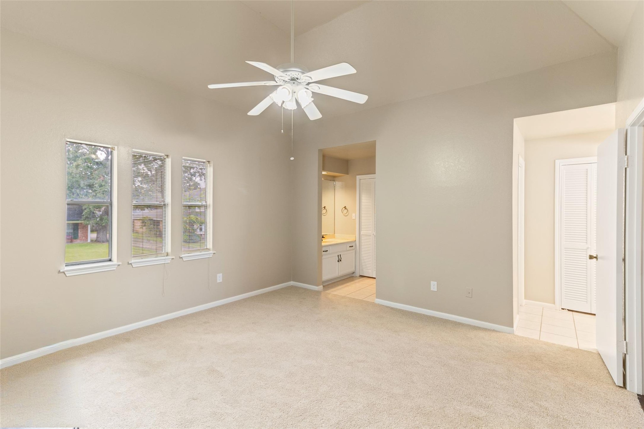 57 South Bachelor Button Street Lake Jackson, TX 77566 - Photo 19 of 29 Full view of the Primary Bedroom & Primary Ensuite Bathroom well-designed layout complete with dual vanities, double walk-in closets & recently replaced carpet throughout all bedrooms.