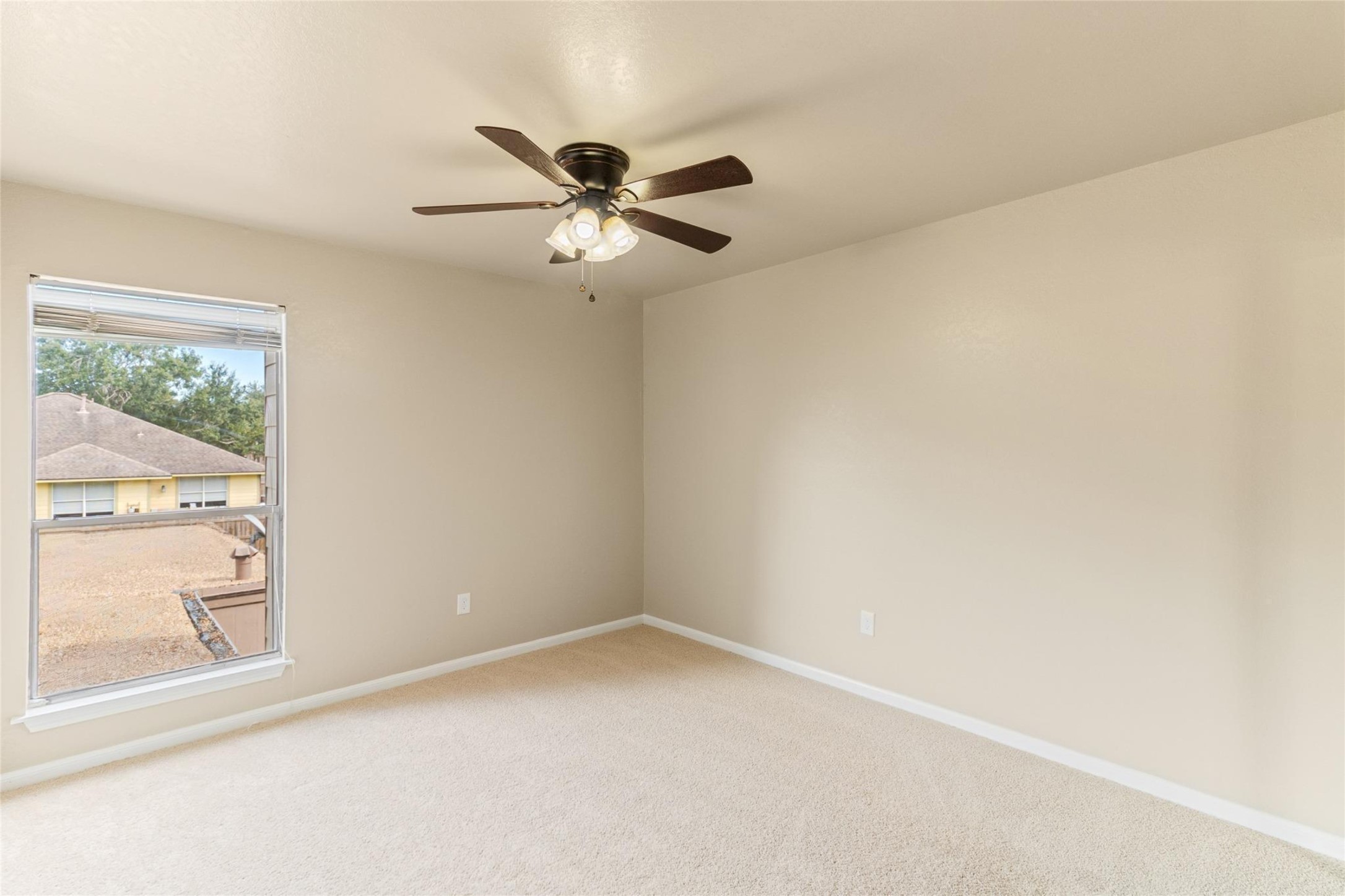 57 South Bachelor Button Street Lake Jackson, TX 77566 - Photo 20 of 29 Bedroom #2 (11x15) offers fresh carpet, neutral tones, and great natural light—creating a comfortable and inviting space.