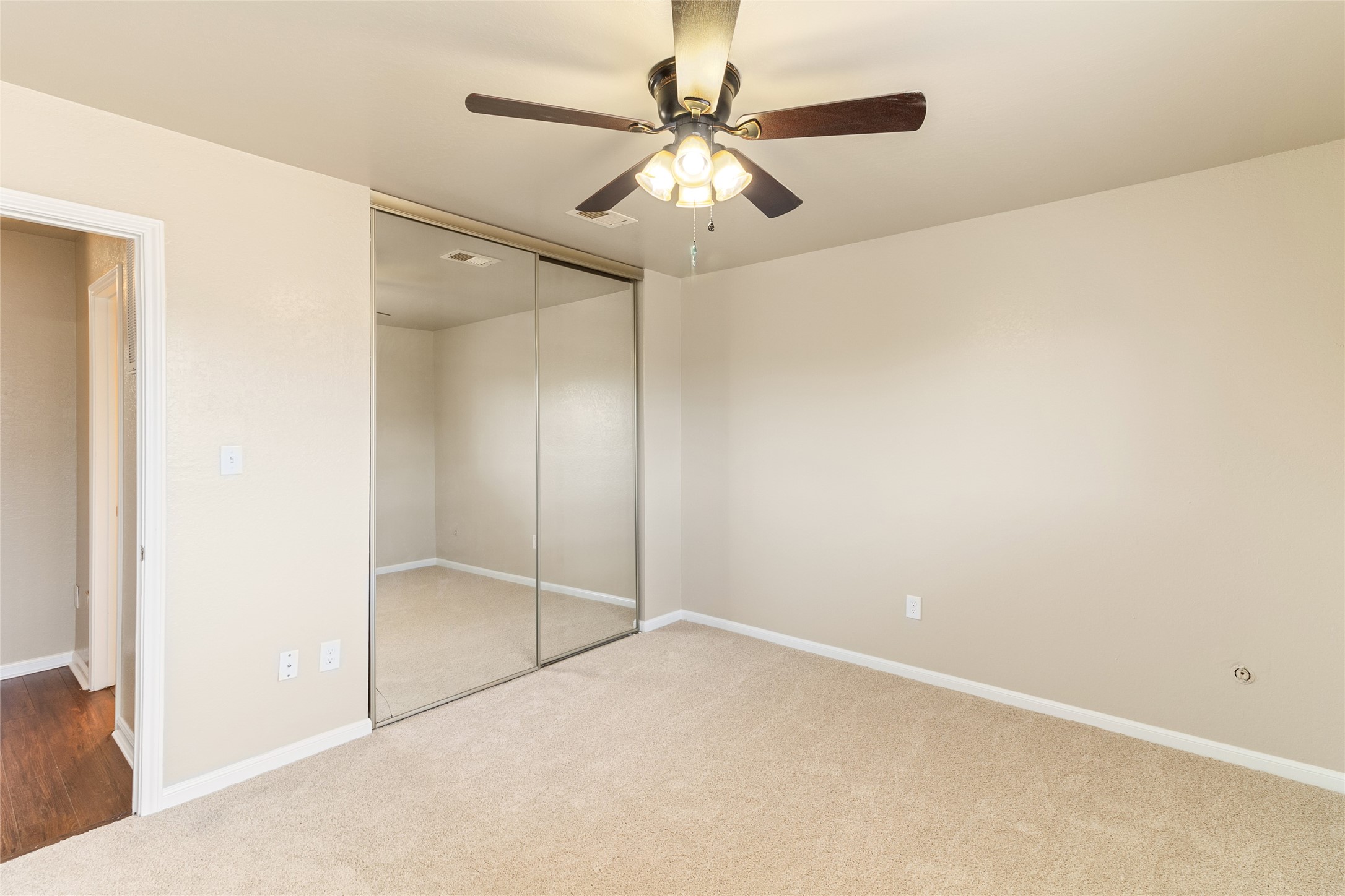 57 South Bachelor Button Street Lake Jackson, TX 77566 - Photo 24 of 29 Another view of Bedroom #3 showcases the mirrored closet doors and easy access to the upstairs landing, which has been updated with stylish new vinyl flooring.
