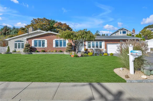 a front view of a house with a garden and yard