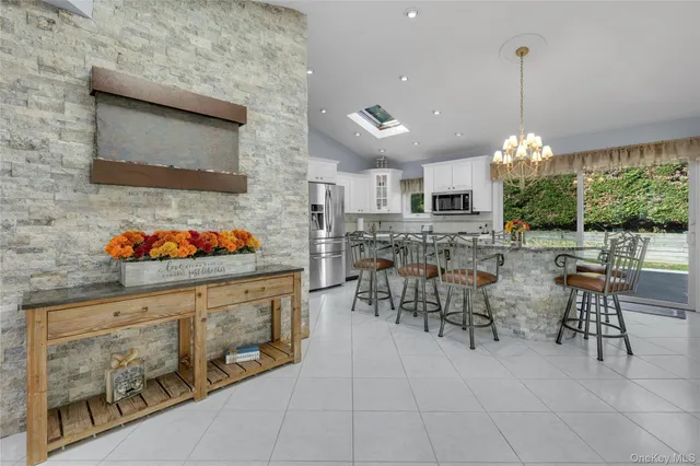 a kitchen with stainless steel appliances granite countertop a table and chairs in it