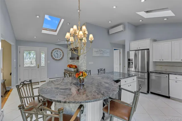 a dining room filled chandelier and kitchen view