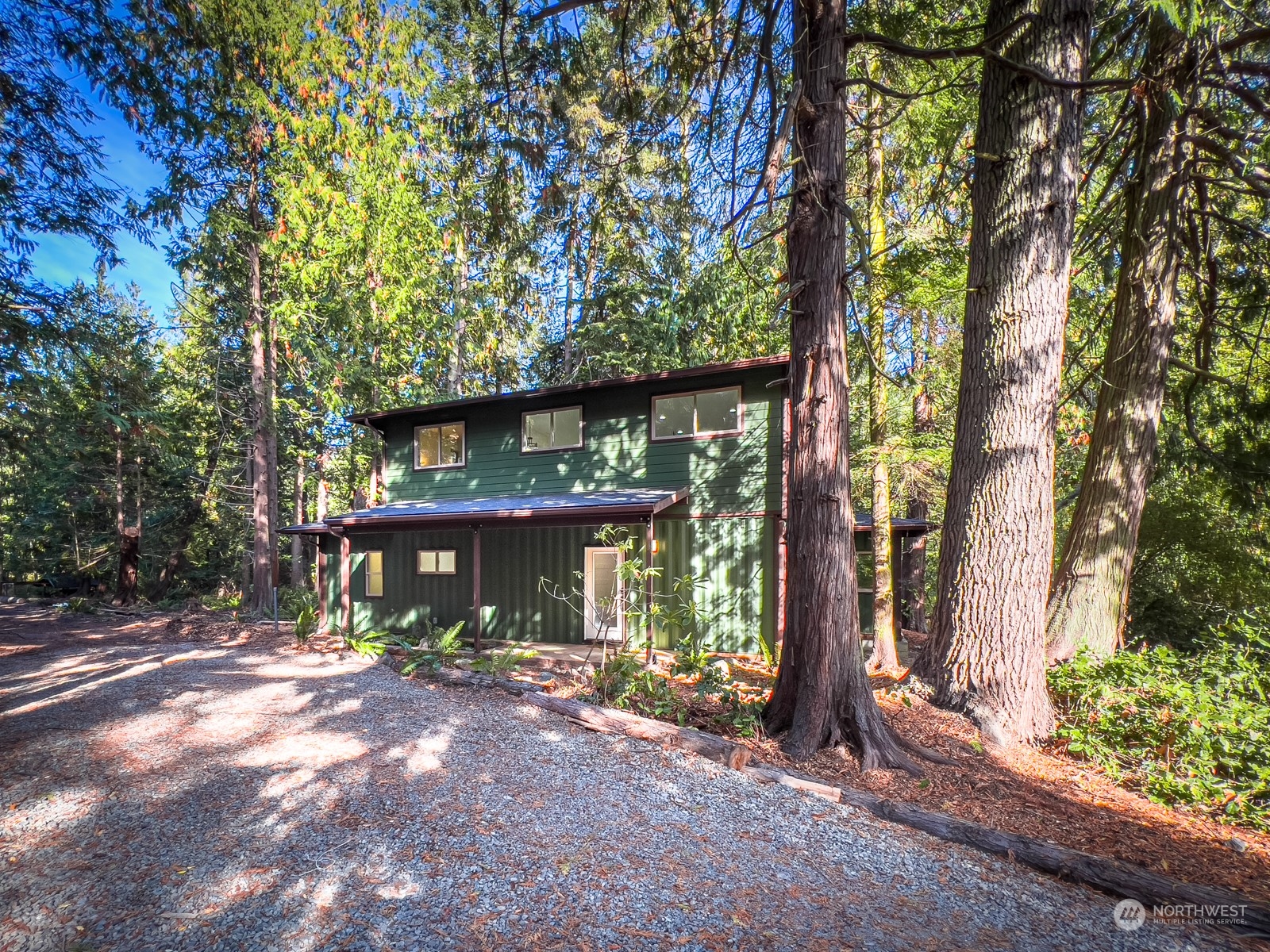 a view of a house with a tree and wooden fence
