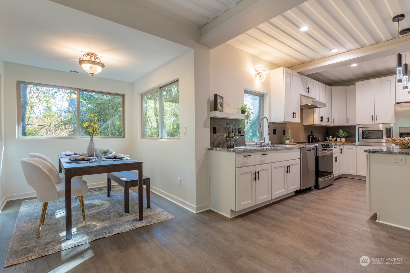 4901 Cleveland Street Port Townsend, WA 98368 - Photo 12 of 39 a kitchen with white cabinets and wooden floor