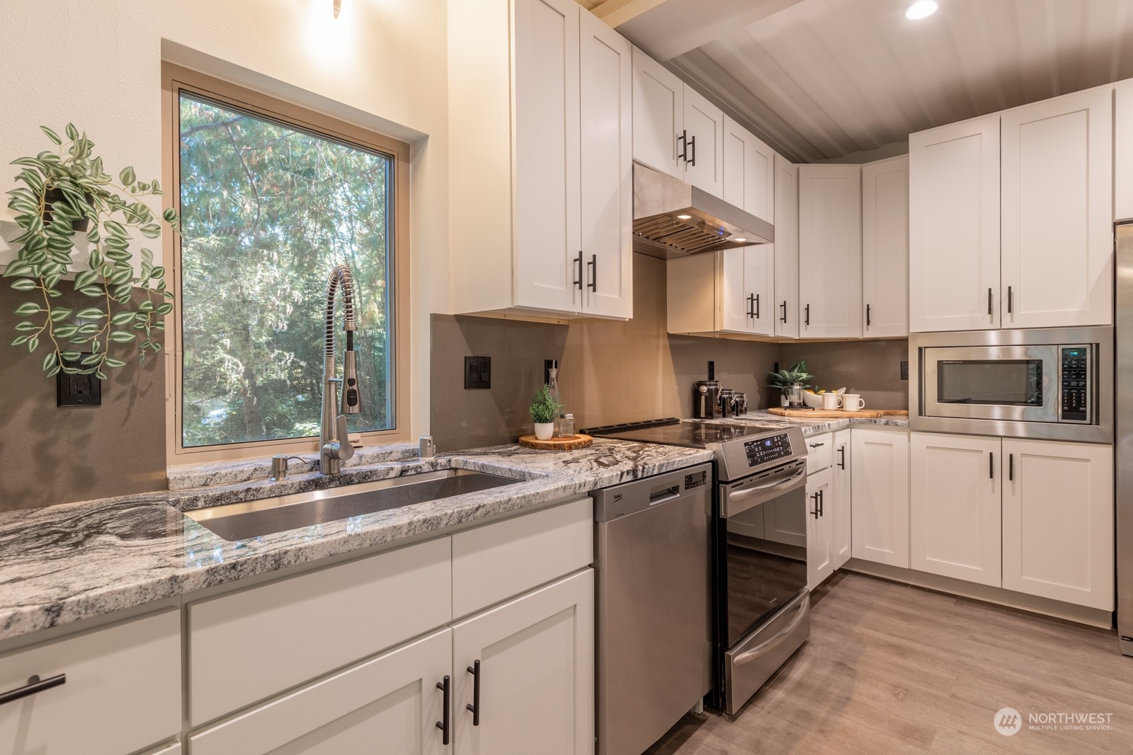 4901 Cleveland Street Port Townsend, WA 98368 - Photo 16 of 39 a kitchen with granite countertop white cabinets and white appliances
